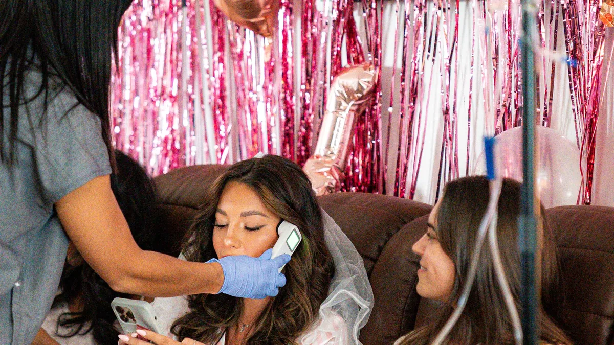 A Drip Lab TN nurse delivering pre-wedding IV therapy to a bride wearing her veil in Nashville