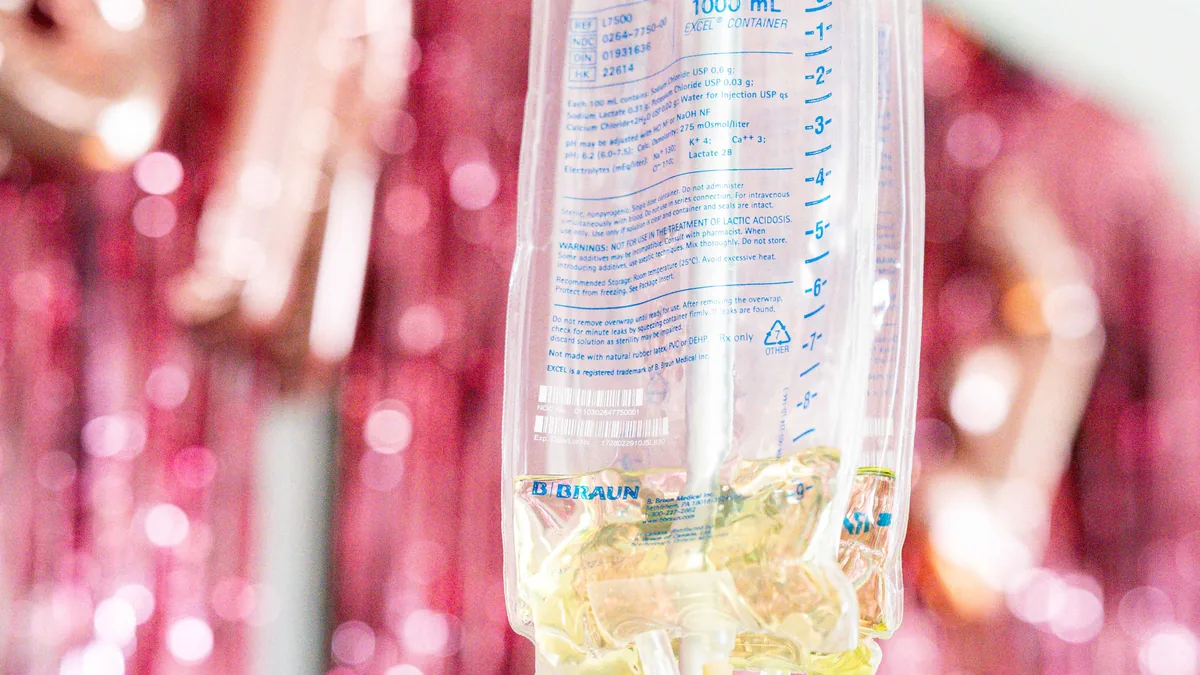 Drip Lab TN clear IV bag against rose-gold party decor at a Gulch Nashville rental