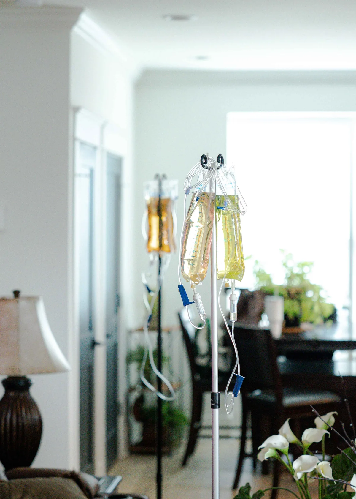 The Drip Lab TN IV stand with amber bags showing the cost and value of mobile IV therapy in Nashville